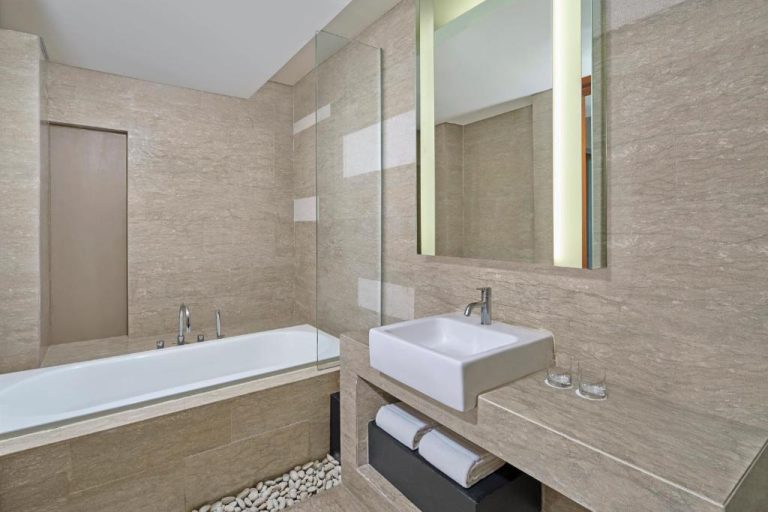 Baño de lujo con bañera y lavabo en mármol del Courtyard by Marriott Bali Nusa Dua Resort