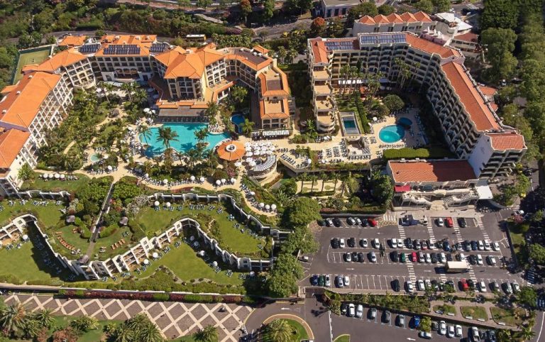 Vista aérea del Hotel Porto Mare PortoBay con piscinas exteriores, jardines tropicales y aparcamiento en Madeira