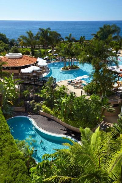 Piscinas tropicales con palmeras y vistas al mar del Hotel Porto Mare PortoBay en Madeira