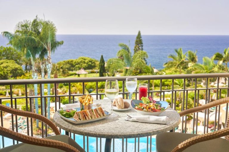 Terraza con almuerzo y vistas al mar y piscina en Hotel Porto Mare PortoBay Madeira