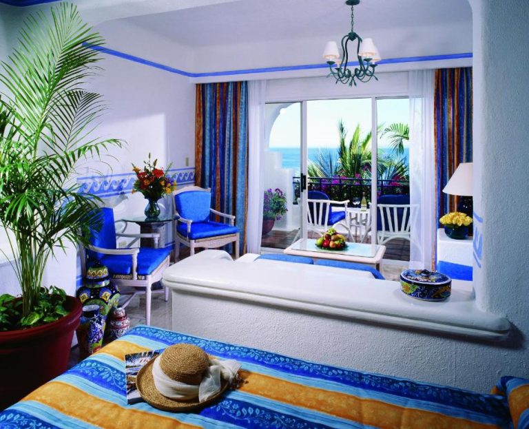 Habitación con decoración azul y blanca con terraza y vista al mar en Pueblo Bonito Los Cabos Blanco Beach Resort