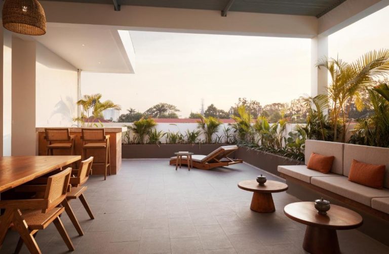Terraza lounge exterior con sofás y mesas de madera en Plantation Urban Resort & Spa