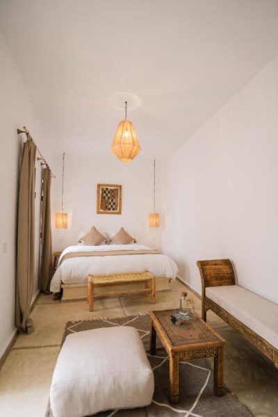 Habitación doble con decoración marroquí tradicional y lámpara artesanal en Riad Rahal