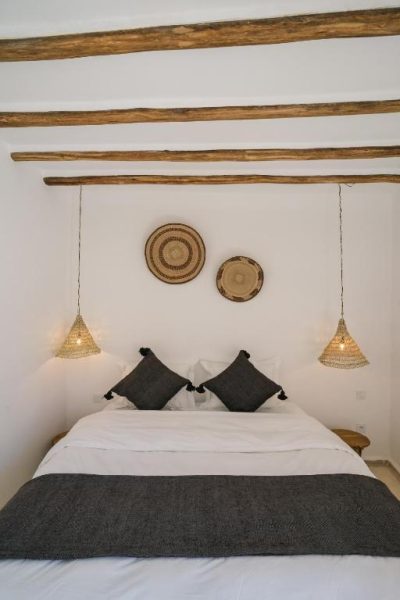 Habitación doble con vigas de madera y lámparas artesanales en Riad Rahal Marruecos