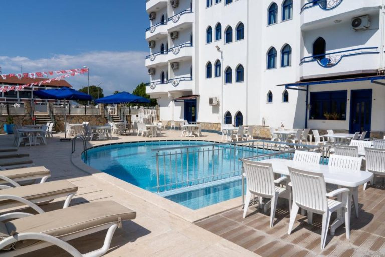 Piscina exterior con terraza, tumbonas y zona de restaurante del Eroglu City Hotel en Turquía