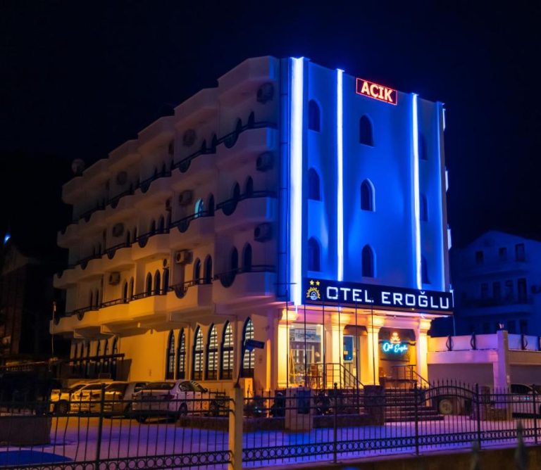 Fachada nocturna iluminada con luces azules y neón del Eroglu City Hotel en Turquía