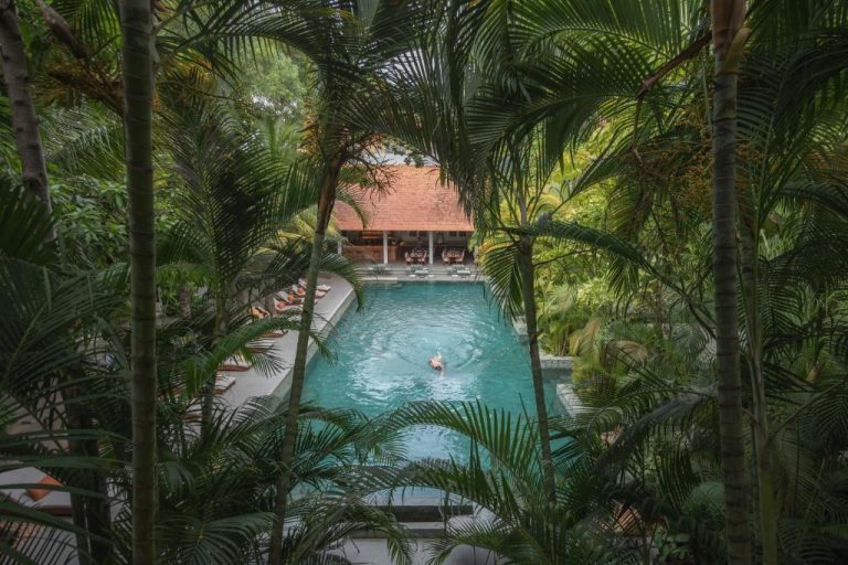 Piscina exterior rodeada de vegetación tropical en Plantation Urban Resort & Spa