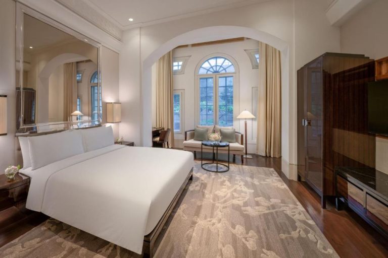 Lujosa habitación suite con cama doble y salón en The Capitol Kempinski Hotel Singapore