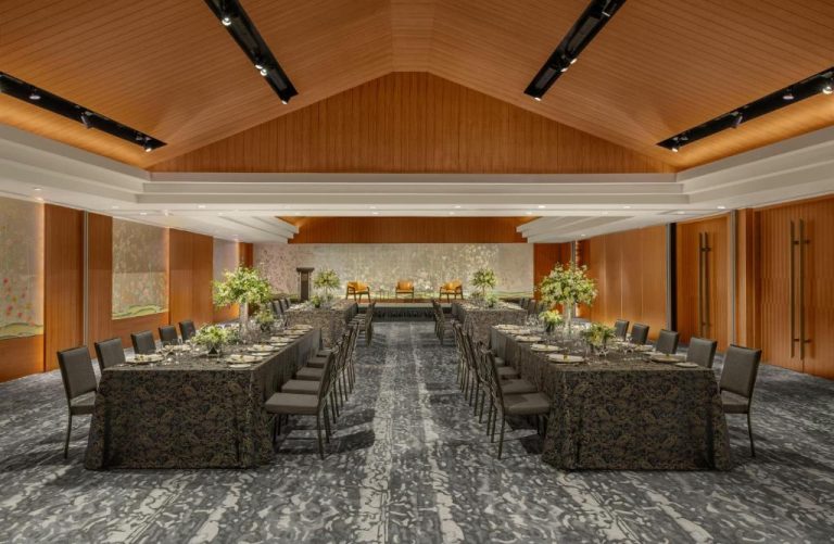 Elegante salón de banquetes con mesas decoradas y flores en The Capitol Kempinski Hotel Singapore