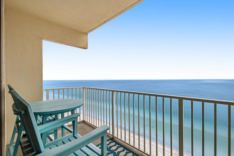 Balcón con sillas y mesa azules con vistas al mar turquesa en Shores of Panama 2030