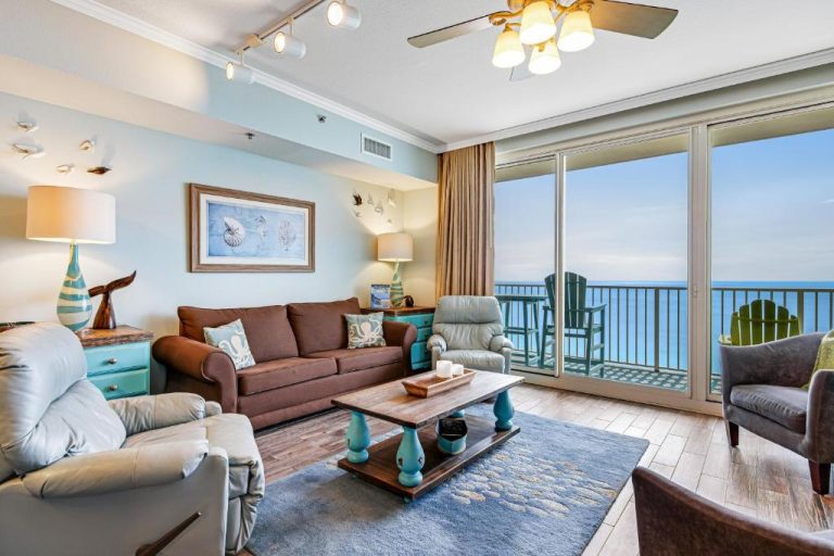 Sala de estar con sofás, decoración costera y balcón con vistas al mar en Shores of Panama 2030
