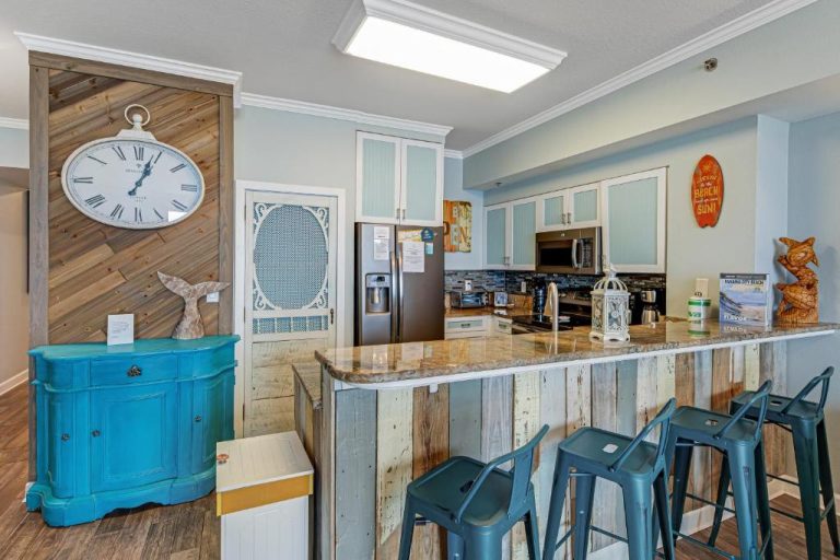 Cocina moderna con barra de desayuno y taburetes en el apartamento Shores of Panama 2030 en Panama City Beach