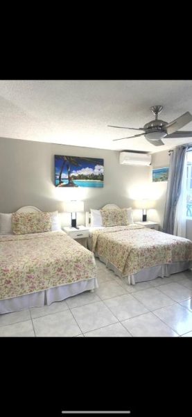 Habitación doble con dos camas florales y aire acondicionado en Ocho Rios Vacation Resort Jamaica