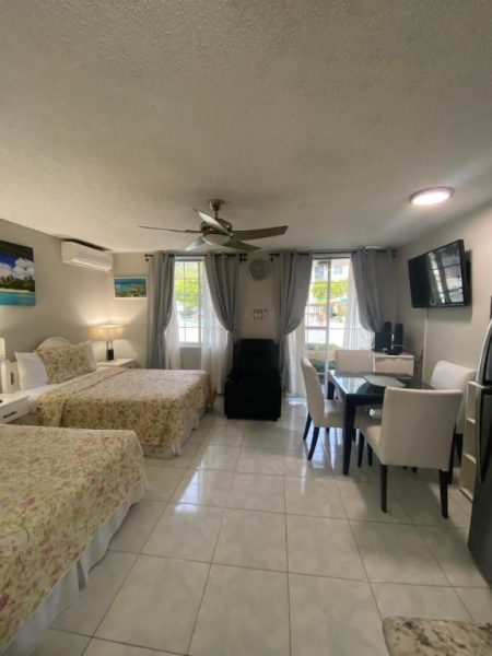 Habitación estudio con dos camas dobles, zona de comedor y TV en Ocho Rios Vacation Resort