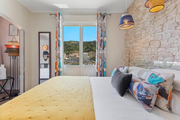 Habitación doble con pared de piedra y vista al puerto en el Hotel Solemare