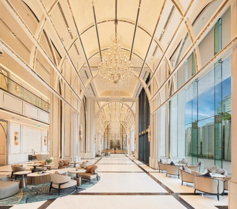Lujoso lobby del Eastin Grand Hotel Phayathai con arcos blancos y grandes lámparas de cristal