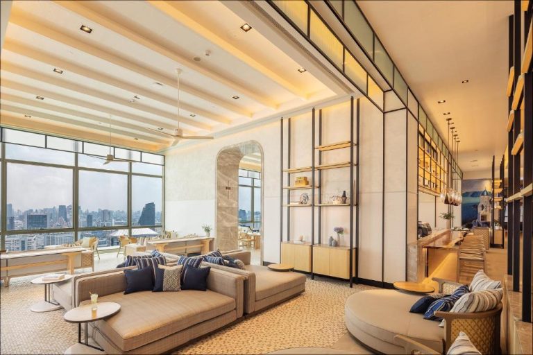 Elegante lobby lounge con sofás y vistas panorámicas a Bangkok en el Eastin Grand Hotel Phayathai