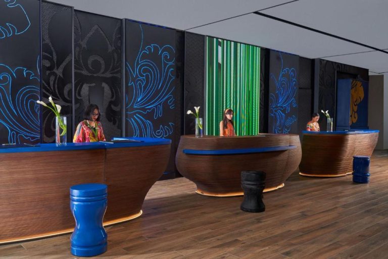 Recepción moderna del Marriott's Bali Nusa Dua Terrace con decoración balinesa y mostradores en madera