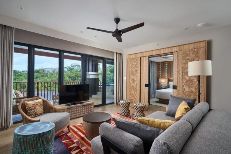 Suite con salón, sofá gris y acceso a terraza con vistas al jardín en Marriott's Bali Nusa Dua Terrace