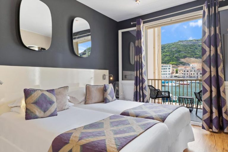 Habitación doble con balcón y vistas al puerto en Hotel Solemare, decoración moderna en tonos grises y morados