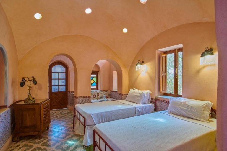 Habitación doble con arcos de estilo oriental y camas individuales en el Al Moudira Hotel de Luxor