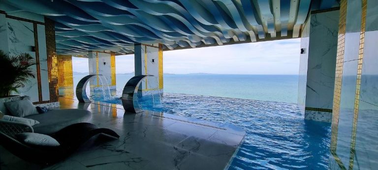 Piscina infinita interior con vistas al mar en Copacabana Pattaya Seaview, con fuentes y techo ondulado