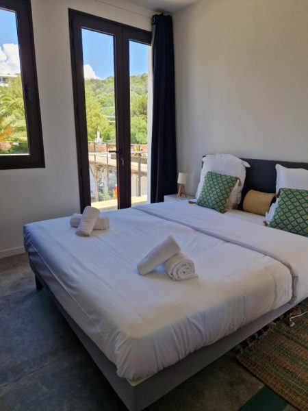 Habitación doble con cama matrimonial y balcón con vistas al exterior en Hotel L'Escale