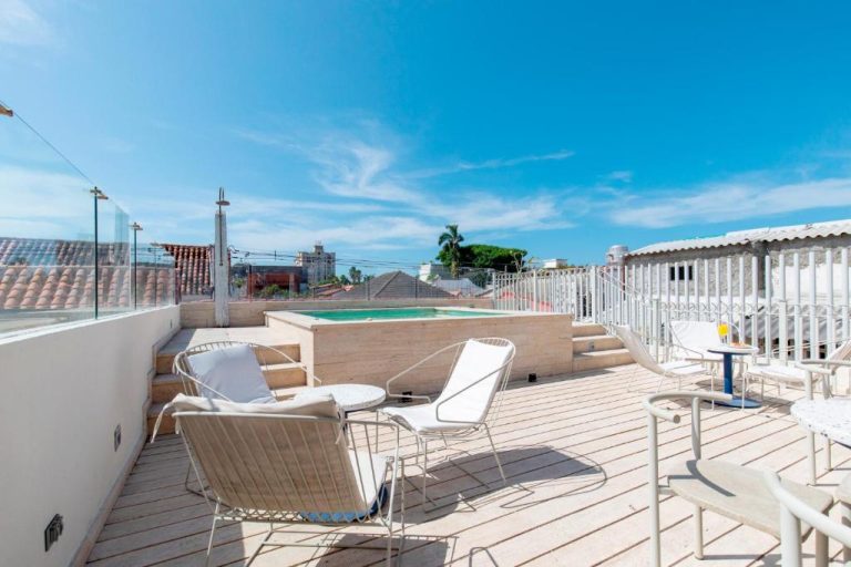 Terraza rooftop con piscina y tumbonas blancas del B Haus Hotel Boutique bajo cielo azul