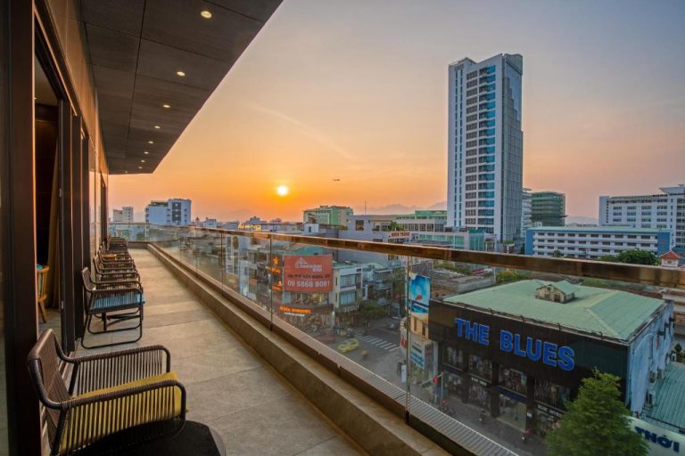 Terraza con sillas y vistas panorámicas al atardecer de Da Nang desde el G8 Luxury Hotel