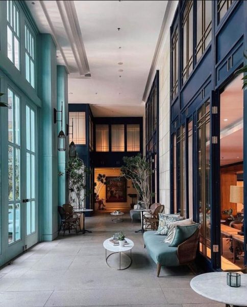 Elegante lobby interior con sofás y grandes ventanales del Kanvaz Village Resort Seminyak en Bali