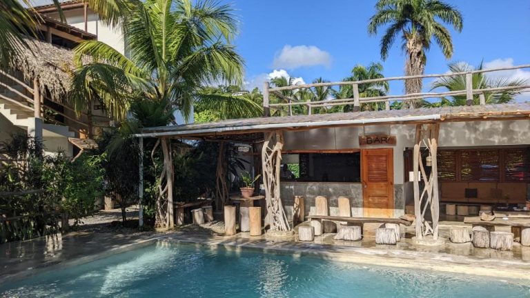 Bar junto a la piscina exterior con decoración rústica de madera en Residencia El Balatà