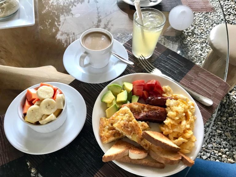 Desayuno completo con huevos, tostadas, aguacate, frutas y café en Residencia El Balatà