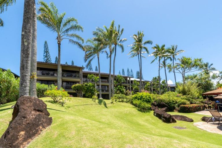 Jardines tropicales con palmeras y edificio del Hanalei Bay Resort en Kauai, Hawaii