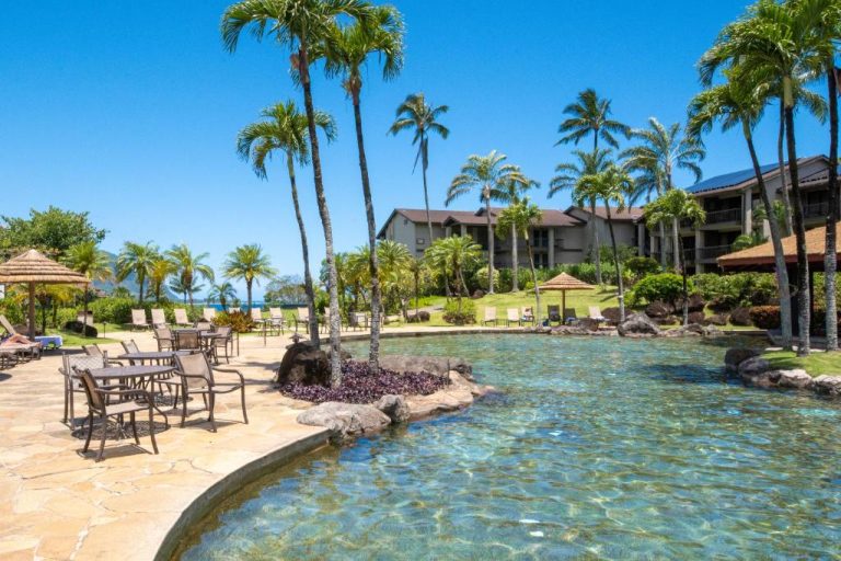Piscina exterior con palmeras tropicales y terraza del Hanalei Bay Resort en Kauai, Hawaii