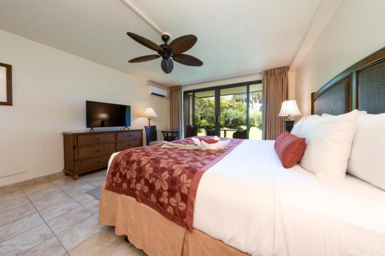 Habitación con cama king size, ventilador de techo y terraza con jardín en Hanalei Bay Resort