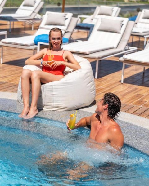 Pareja disfrutando de cócteles junto a la piscina del Cleopatra Luxury Resort Sharm Adults Only