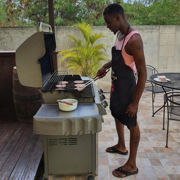Huésped cocinando en la barbacoa exterior de la terraza de Best E Villas Prospect St James