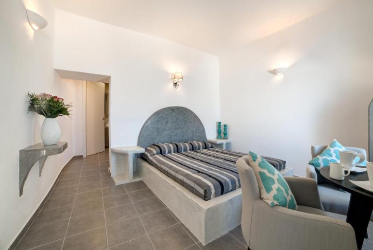 Habitación doble con cama empotrada y decoración estilo cicládico en Remvi Suites Santorini