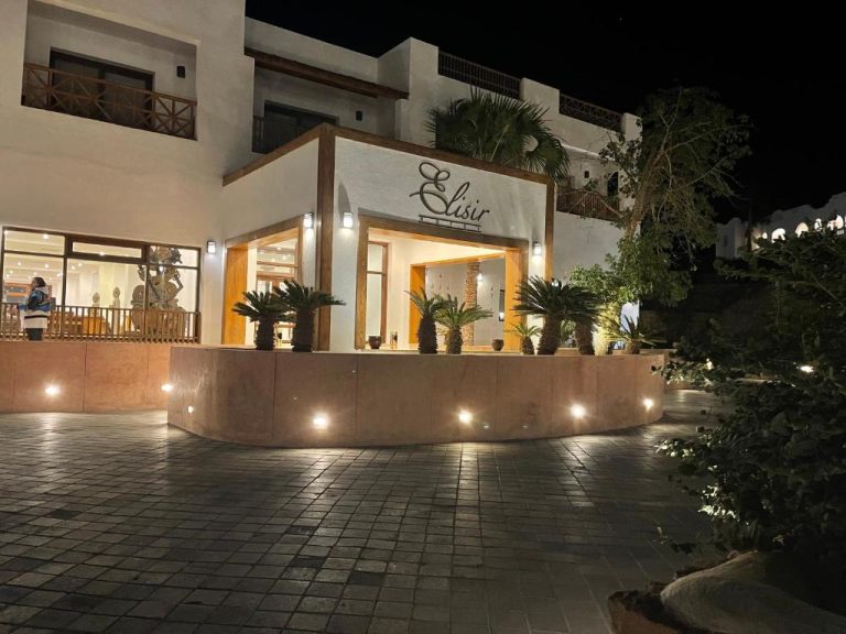 Fachada exterior iluminada del Elisir SPA & Hotel en la costa de Sheikh durante la noche