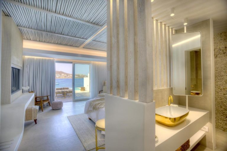 Habitación de lujo con baño dorado y vistas al mar en el Icon Mykonos Hotel