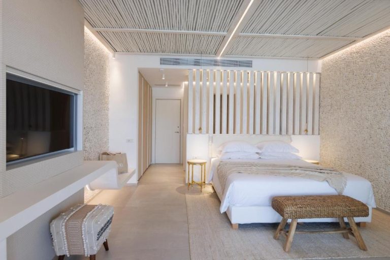Habitación deluxe de diseño minimalista con cama king size y decoración en blanco en Icon Mykonos