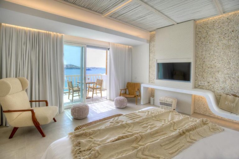 Habitación de lujo con vistas al mar y terraza privada en Icon Mykonos, decoración en tonos blancos