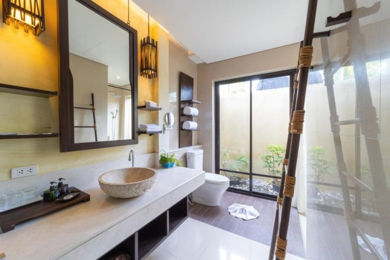 Baño de villa privada con lavabo de piedra natural y jardín exterior en TUI BLUE The Passage Samui
