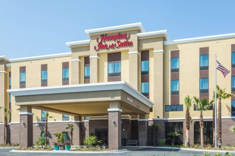 Fachada exterior del Hampton Inn & Suites Fort Walton Beach con entrada principal y palmeras