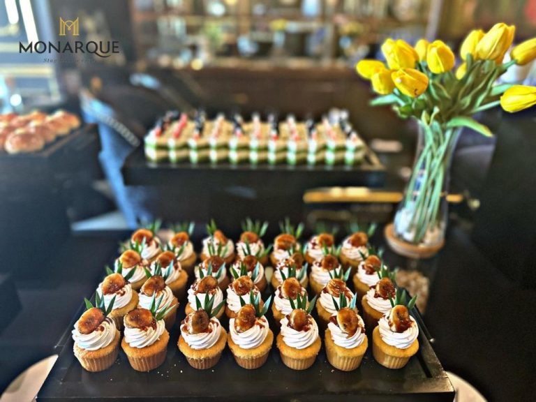 Selección de cupcakes y postres del buffet en Monarque Hotel Danang con decoración de tulipanes amarillos