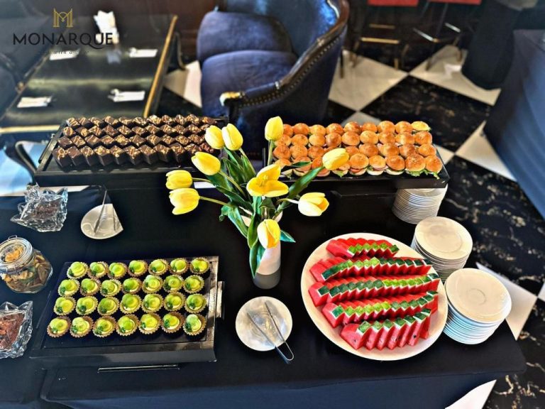 Mesa de buffet con canapés, sandwiches, tartaletas y sandía en el Monarque Hotel Danang