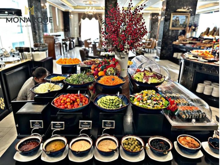Amplio buffet de desayuno con ensaladas frescas, frutas y sushi en el Monarque Hotel Danang