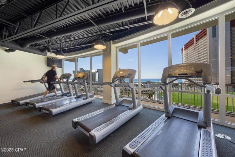 Gimnasio con cintas de correr y vistas panorámicas al mar en Laketown Wharf Resort Panama City Beach