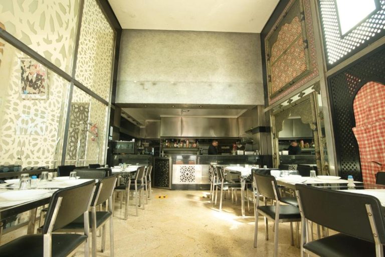 Restaurante con cocina abierta y decoración árabe del Appart Hôtel Founty Beach en Agadir