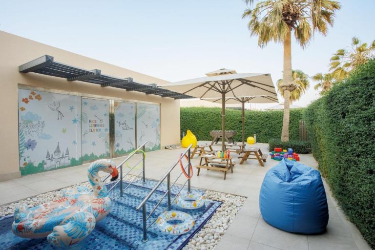 Kids Learning Center con piscina infantil, flotadores y zona de juegos exterior en The St. Regis Doha